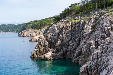 KRK Island, Vrbnik, Croatia - April 19, 2025: Cityscape. View of the coastline, rocky beach, and mountains
