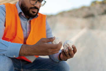Engineer holding white limestone rocks in hands at quarry site selective focus on hands