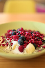Homemade yoghurt with fresh berries and chia seeds in plate on a wooden table