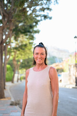 Portrait of a smiling mature Scandinavian tourist woman walking in the street in Spain