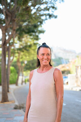 Portrait of a smiling mature Scandinavian tourist woman walking in the street in Spain