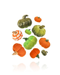 Knitted orange and green pumpkins on white background, autumn composition. Halloween concept.