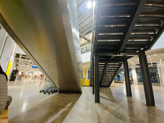 Modern Escalator and Black Iron Stairs Viewed from Below in Commercial Building Interior