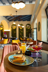 Food, sandwich, and cocktails served on a table in a café restaurant
