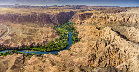 Impressive panorama of Charyn Canyon in Kazakhstan, featuring a meandering river and unique rock...