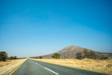 A road winding through the savanna north of Windhoek, Namibia