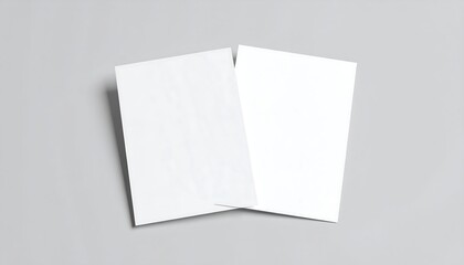 Two blank white posters on a gray surface