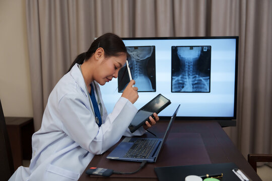 A female doctor is checking the X-ray scan results of a bone patient.