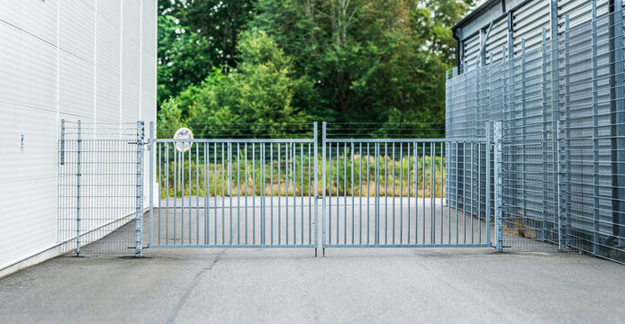 Industrial metal gate entrance between warehouse buildings.