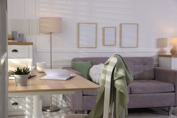 Wooden table, chair and sofa in living room. Interior design