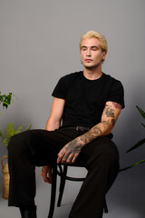 Fototapeta premium Stylish young man exudes confidence in modern setting with a touch of youth culture