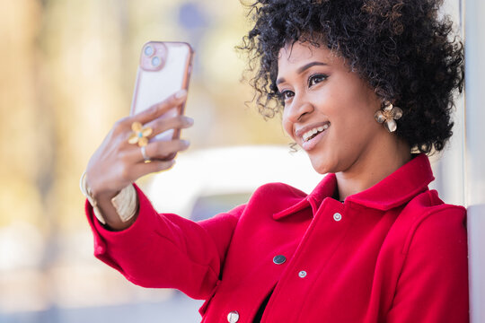 young african american woman with mobile phone recording or taking a selfie