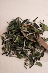 Green tea leaves on a wooden board with a spoon. Tea ceremony. Herbal treatment.