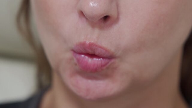 a woman in the act of whistling, showcasing her pursed lips and the focused expression associated with creating the musical sound.