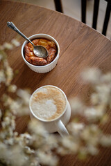 Cottage cheese souffle. Side view. A flowering branch in a vase. Souffle in a ramekin .