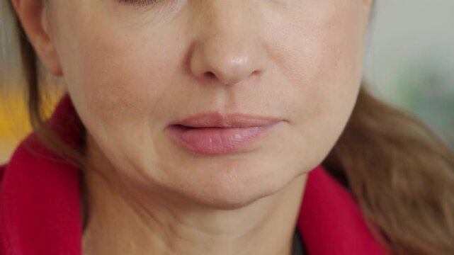 a woman smacking her lips, portraying a feeling of satisfaction or contentment, perhaps after enjoying a delicious meal.