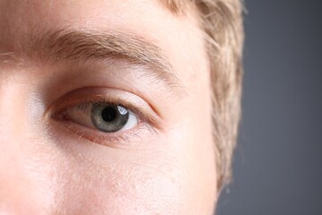 Obraz premium Man with beautiful eyes on grey background, closeup