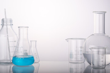 Laboratory equipment beakers and flasks with backlight in different group. Space for products presentation.