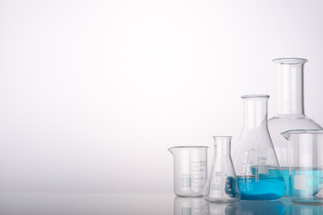 Laboratory equipment beakers and flasks with backlight in different group. Space for products presentation.