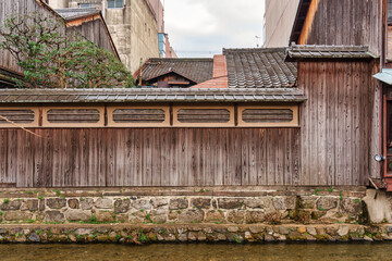 Old wooden wall of achitecture japanese house with canal waterfront stone in Kyoto