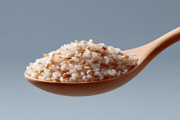 Close-Up View of Brown and White Rice Piled on a Wooden Spoon against Gray Background