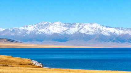 Lake and snow mountains under blue sky