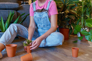 A woman surrounded by several houseplants. 