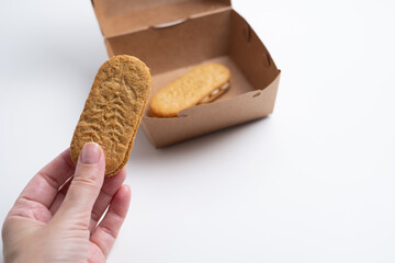 Cookies, handmade cakes, homemade baked goods in craft packaging. A girl's hand takes cookies out of the packaging. Sweet food, snack.
