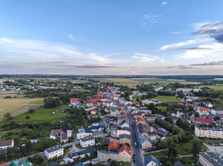 Aerial views of Barwice, West Pomeranian (Zachodniopomorskie), Poland. Picturesque small town with red-brick neo-Gothic church, colorful homes, greenery, and open countryside on a summer afternoon