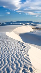White sand dunes under a partly cloudy sky