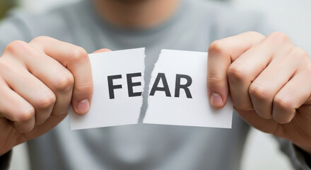 Hands Ripping the Word FEAR Apart on Paper, Overcoming Obstacles