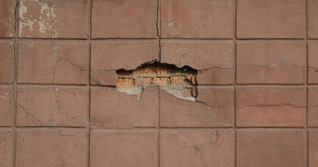An old brick wall with falling plaster