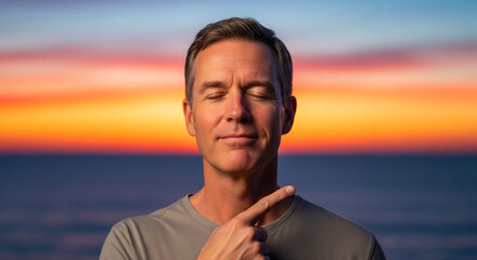 Mature caucasian man with eyes closed pointing at himself, practicing mindfulness and self-awareness during a serene ocean sunset