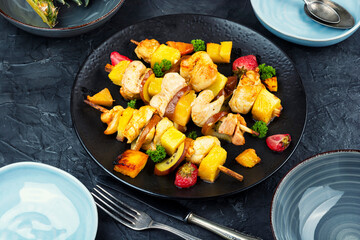 Chicken meat with pineapple on skewers.