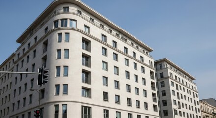 Modern white building with many windows against a clear blue sky, representing architecture and urban development