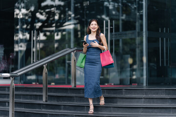 beautiful asia woman female pleased positive casual shopping hand hold paper bags happy woman enjoy purchase cloths shopping buy sales discount at center mall store shopfront corridor department store