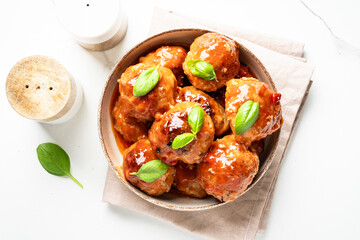 Meatballs in tomato sauce on white background.
