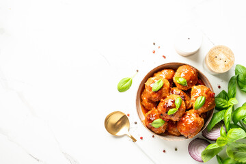 Meatballs in tomato sauce on white background.