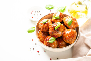 Glazed Meatballs in tomato sauce on white table.