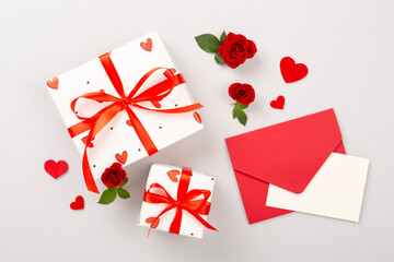 Valentine's Day composition with gifts and red roses on color background, top view