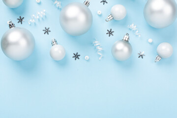 Grey Christmas balls with decor on color background, top view