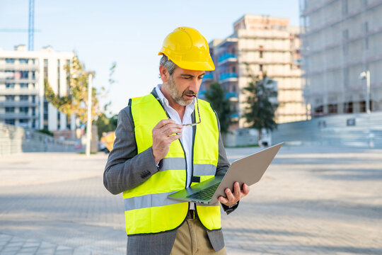Engineer man analyzing construction plans on laptop