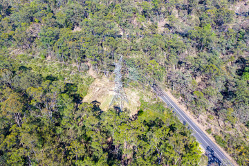 Drone aerial photograph of an electrical transmission tower running through regional bushland in the Blue Mountains in NSW, Australia.