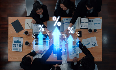 A dynamic business team collaborates over financial reports with rising graphs. The image symbolizes growth and strategic planning in a modern office setting. Trope