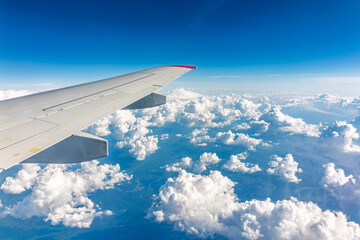 View from the airplane window at a beautiful cloudy sky and the airplane wing