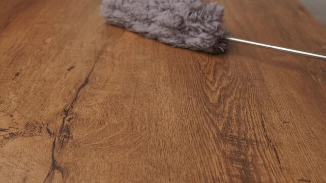 A fluffy feather duster on a polished wood surface is ideal for all your cleaning and dusting tasks