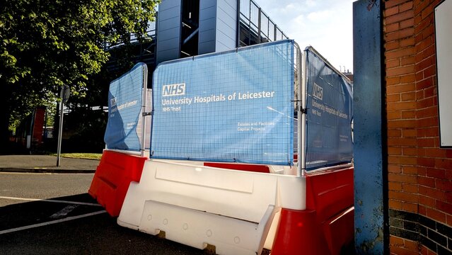 Leicester, England, UK - 14 May 2025: Construction barriers with NHS University Hospitals of Leicester sign