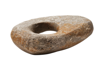 Ancient oval stone artifact with a central hole found at a historical site