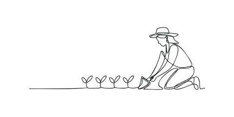 Person watering young plants with watering can