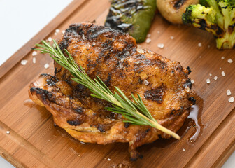 Grilled Chicken Thigh with Rosemary and Roasted Vegetables on a Wooden Board